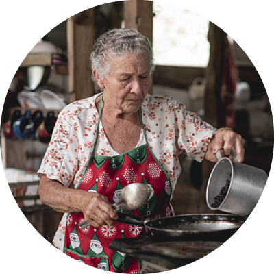 A vertical shot of an old Hispanic woman cooking corn tortillas typical for Costa Rica in Tilaran, Guanacaste, Costa Rica
