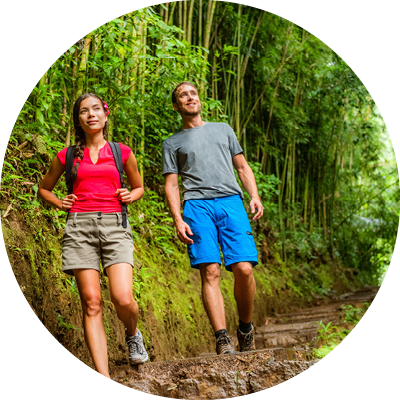 Forest hike hikers hiking in rainforest trail in Hawaii. Interracial couple walking in travel adventure. Asian woman, Caucasian man active lifestyle. Excursion activity.