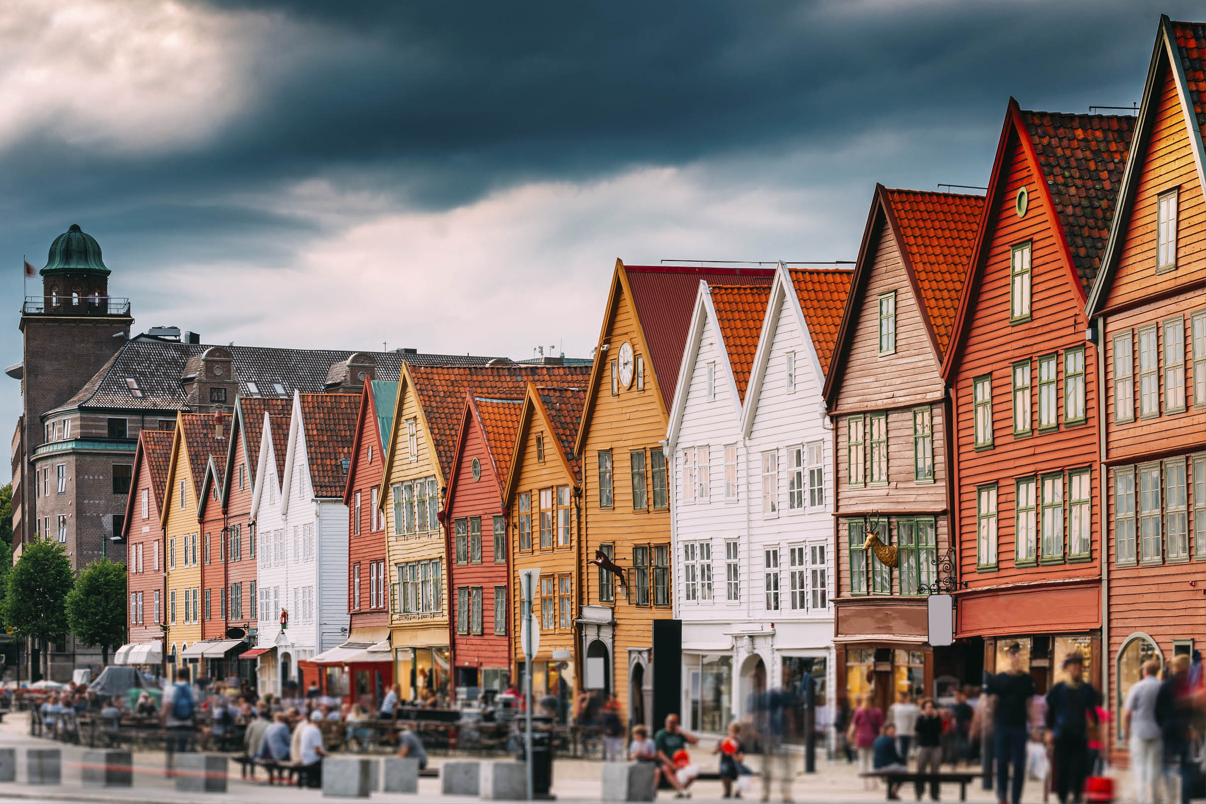 Bergen, Norway. Tourists People Visiting Historical Landmark Houses In Bryggen - Hanseatic Wharf In Bergen, Norway. UNESCO World Heritage Site. Famous Landmark. Destination Scenic