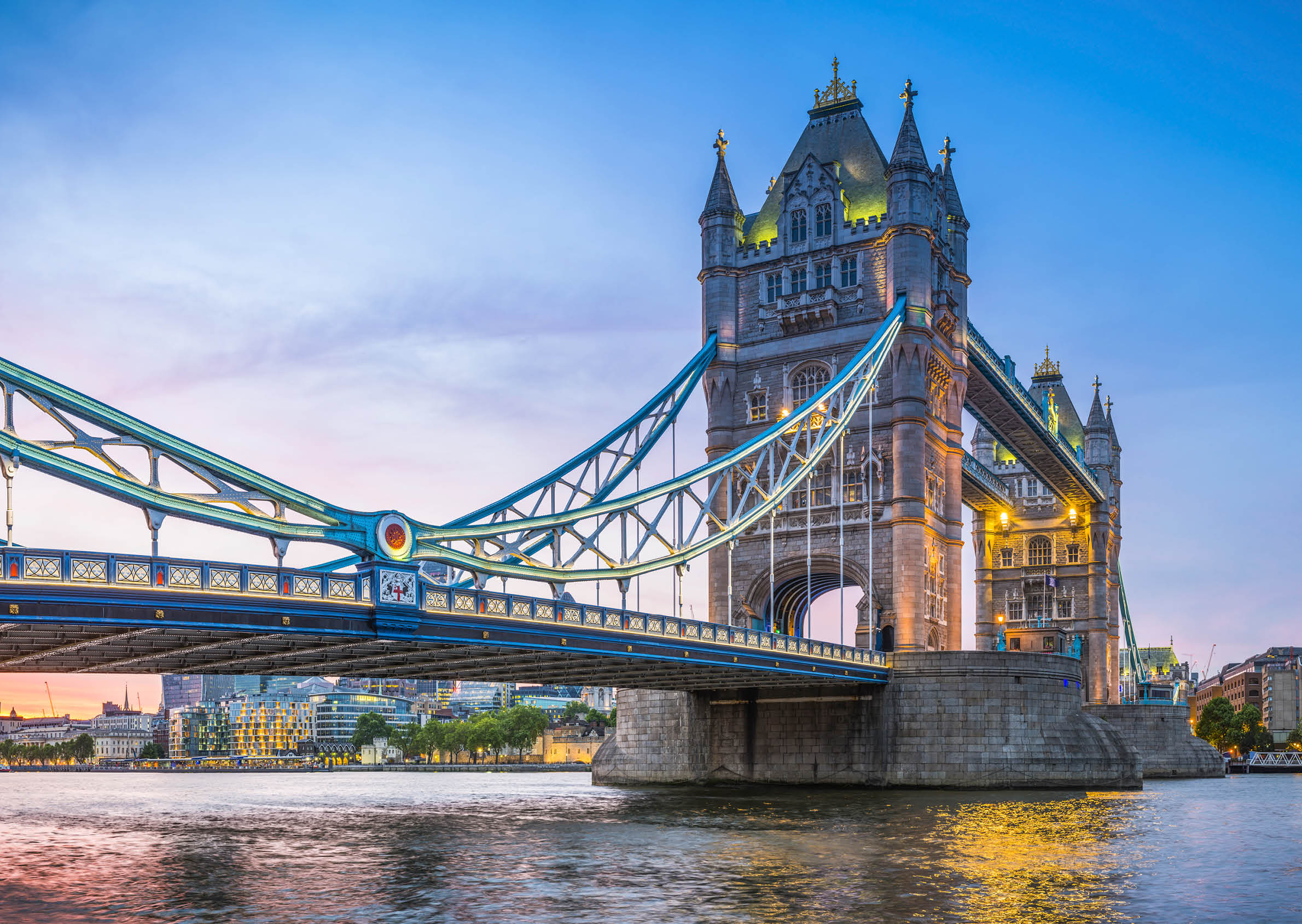 Summer sunset skies above the iconic span of Tower Bridge above the slow moving waters of the River Thames in the heart of London, Britain's vibrant capital city.